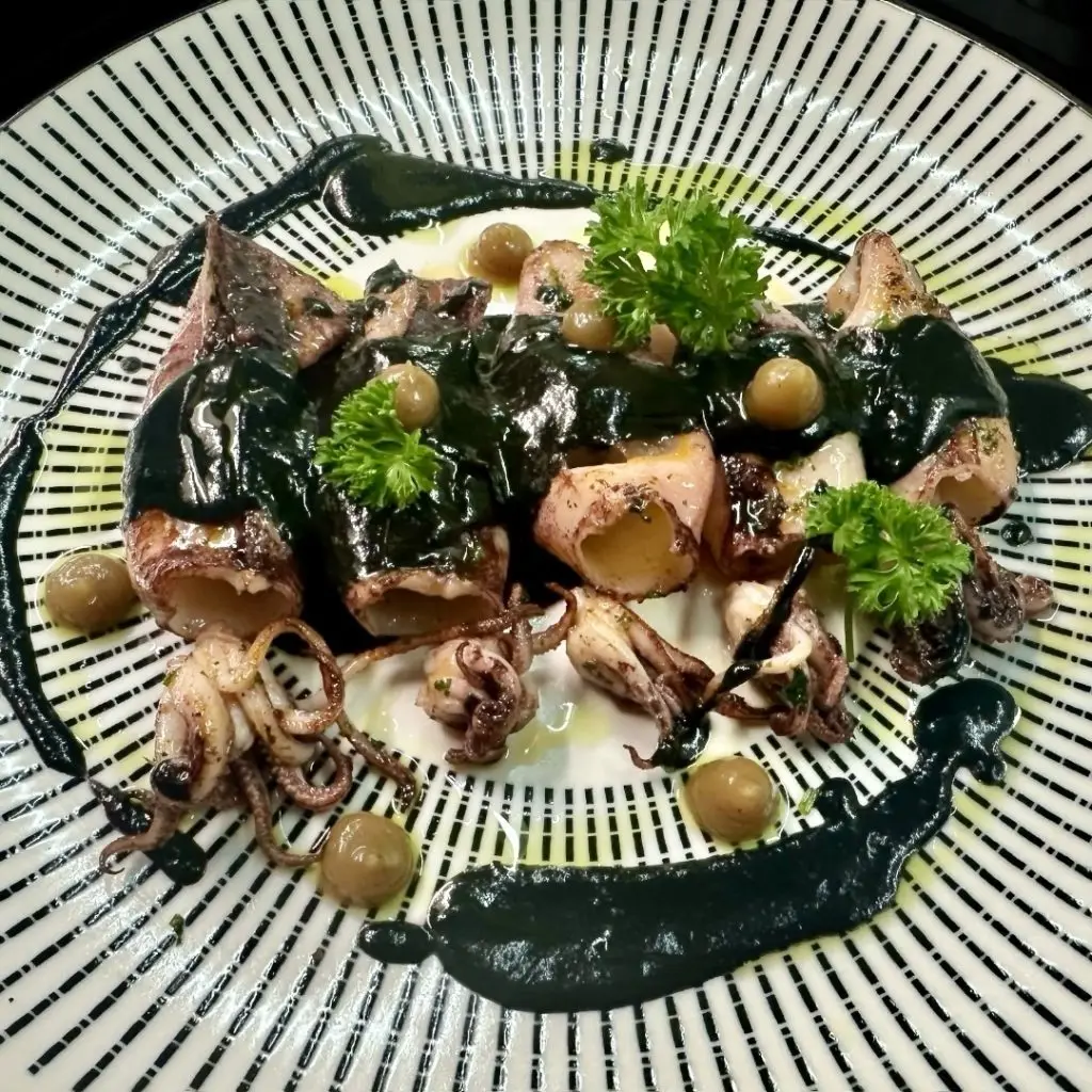 Chipirones con salsa de tinta negra en Madriz Bistro, restaurante español en Crans-Montana